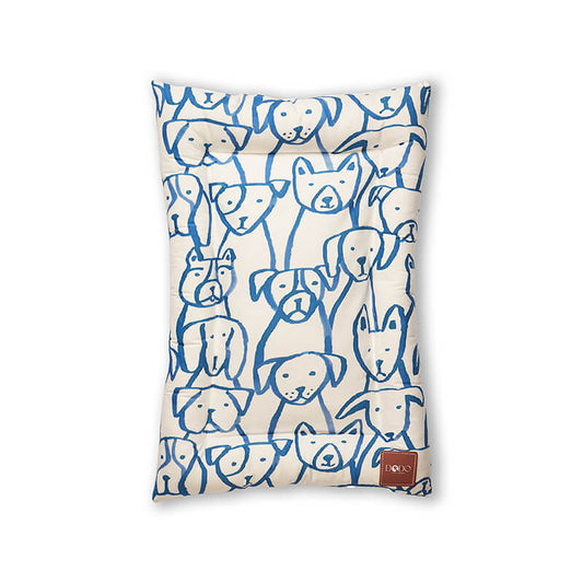 Paw Pop Bed featuring a playful blue dog-face pattern on a soft cream fabric, designed as a comfortable and lightweight pet bed with gentle padding and a visible DODO Pet Care brand tag, ideal for cozy everyday rest for dogs and cats.