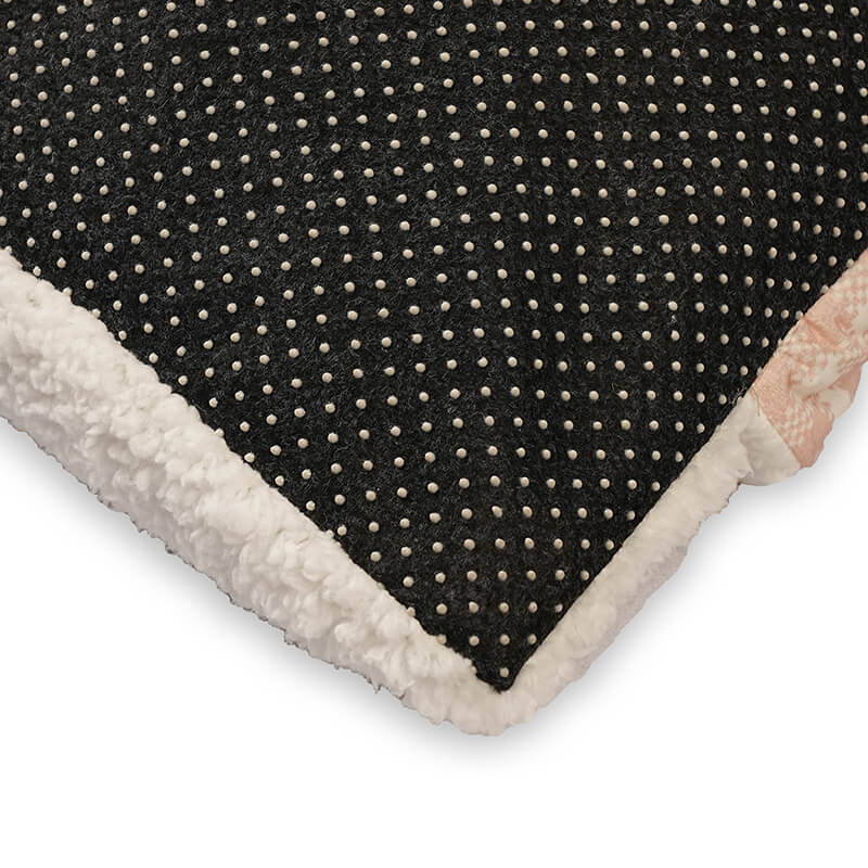 Close-up of the Teddy Snug Bed’s black anti-slip dotted base with soft white fleece edging, designed to prevent sliding and add cozy comfort for pets.