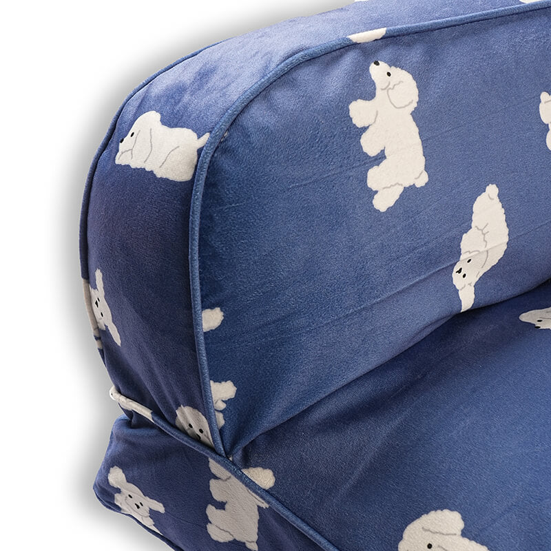 Close-up view of the Luxe Lounge Sofa Bed highlighting the raised cushioned side and backrest, featuring soft blue velvety fabric with white dog prints, smooth piping, and plush supportive padding on a white background.