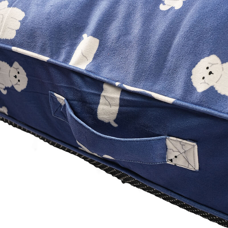 Close-up detail of the blue Luxe Lounge Sofa Bed showing the stitched fabric carry handle, soft velvety upholstery with white dog illustrations, reinforced seams, and textured anti-skid base, isolated on a white background.