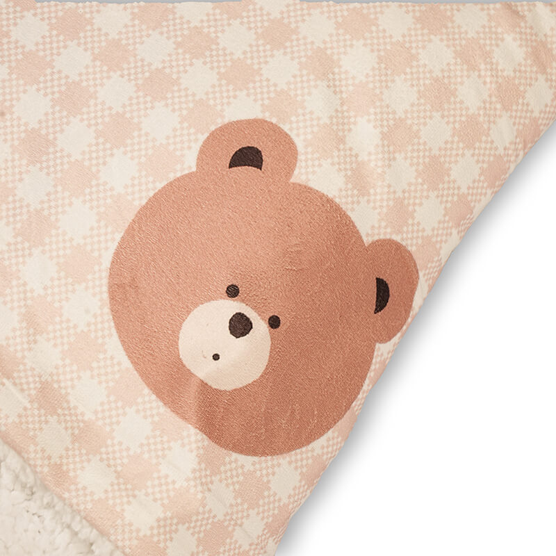 Close-up of the Teddy Snug Bed featuring a soft teddy bear face print on a pastel checkered fabric, highlighting the cozy and cute design for pets.