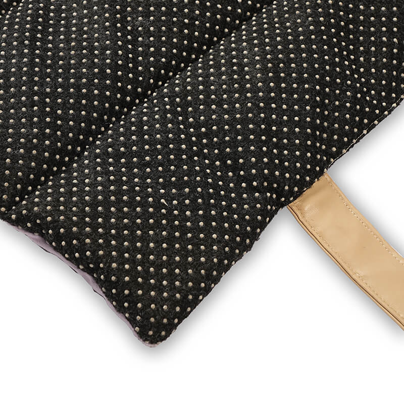 Close-up of Treatos travel mat showing black non-slip dotted base with textured fabric and beige carrying strap, designed to prevent slipping and provide stability for pets.