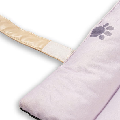 Close-up of Treatos travel mat showing soft pink padded fabric with paw print detail and beige Velcro strap for secure folding and easy carrying.