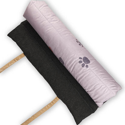 Top view of the Treatos Travel Mat rolled up, showing the soft lavender paw-print fabric on one side and the black anti-slip dotted base on the other, with beige straps for easy carrying during pet travel.
