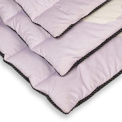 Close-up view of the Treatos Travel Mat showing soft quilted padding with layered edges, lavender fabric surface, and black anti-slip dotted border designed for comfortable pet rest and travel use.