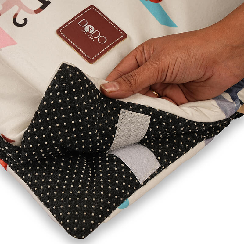 Close-up of a foldable yoga mat showing the anti-slip dotted base and secure Velcro closure, with a hand lifting the corner to highlight grip, padding, and safety during workouts.