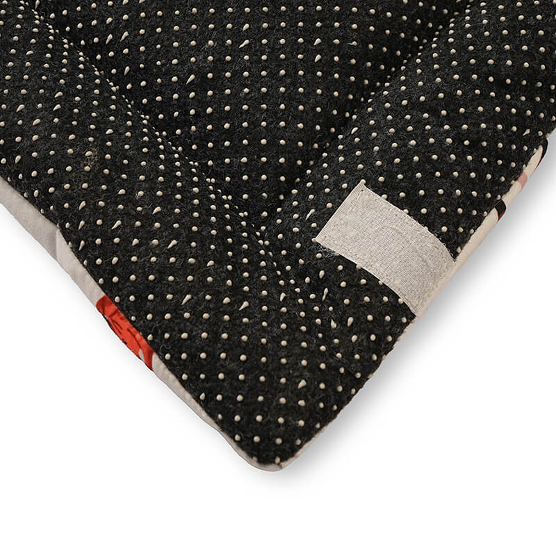 Close-up of the underside of a foldable yoga mat featuring a black anti-slip base with raised dotted grips for enhanced stability and floor protection during workouts.