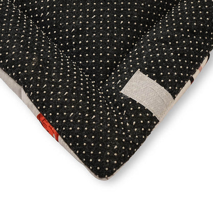 Close-up of the underside of a foldable yoga mat featuring a black anti-slip base with raised dotted grips for enhanced stability and floor protection during workouts.