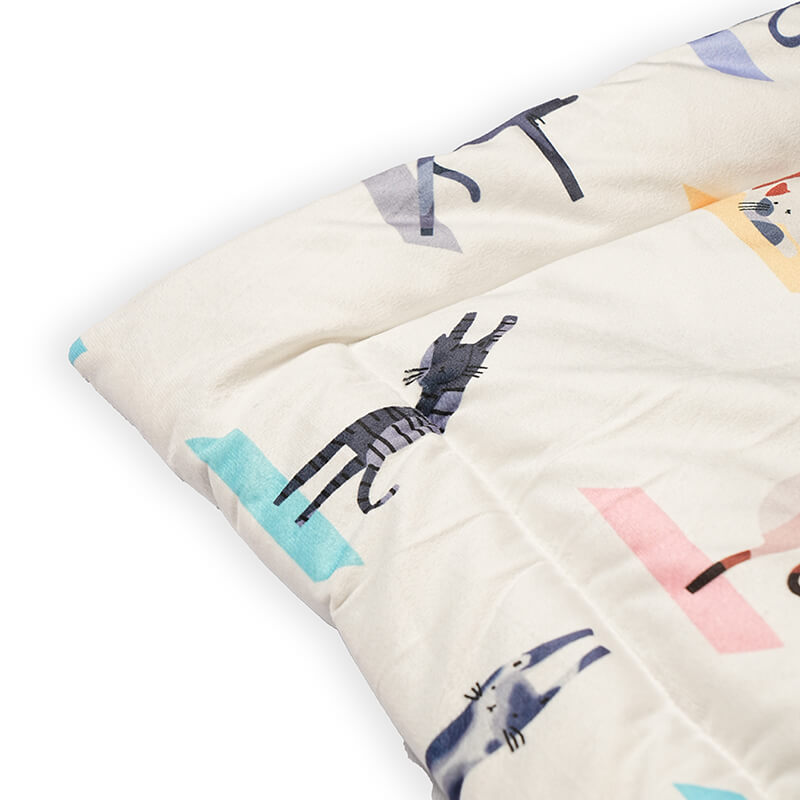 Close-up of the quilted edge of a foldable yoga mat featuring soft padding, smooth fabric finish, and playful animal print design for added comfort and style.